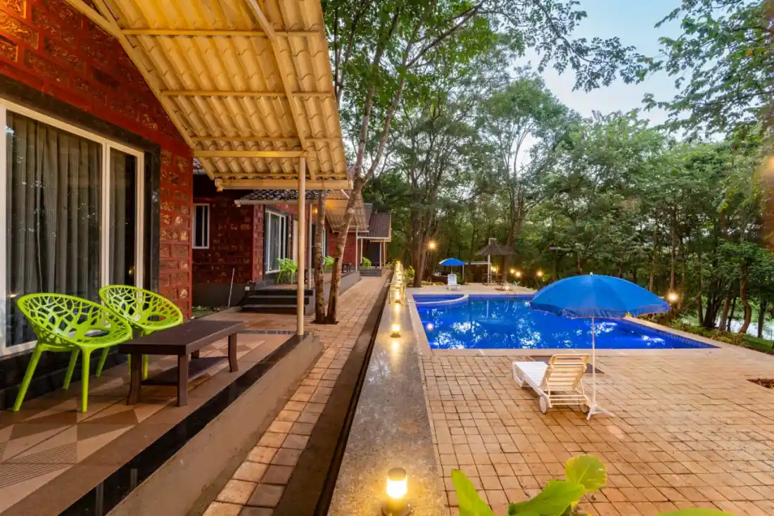 Pool area with loungers and seating at Rain Forest Resort Dandeli