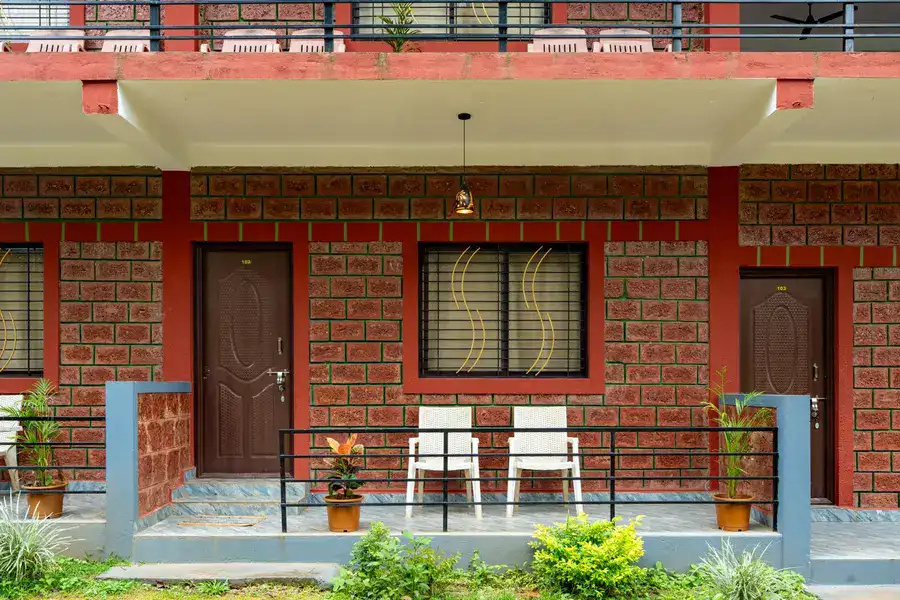 Comfortable room with private veranda overlooking lush gardens at Tusker Trails