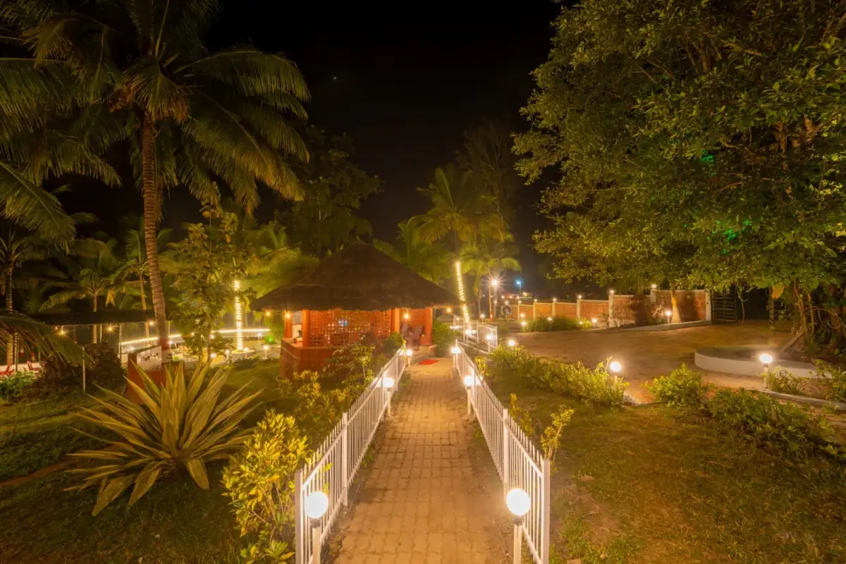 Lit pathway at night leading through Wild Mist resort garden in Dandeli