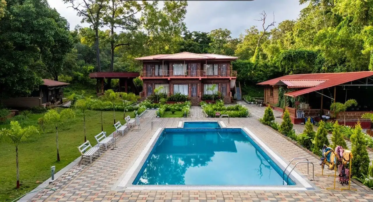 Pool and garden area at Dandeli Safar resort surrounded by greenery