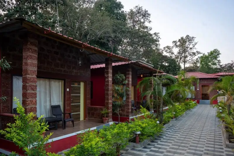 Stone walkway through manicured lawns at Wild Wings Dandeli resort